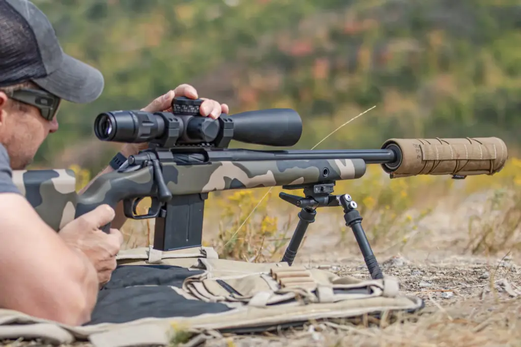 Shooter prone behind a camo bolt-action rifle on the Atlas CAL BT65-LW17 bipod at the range