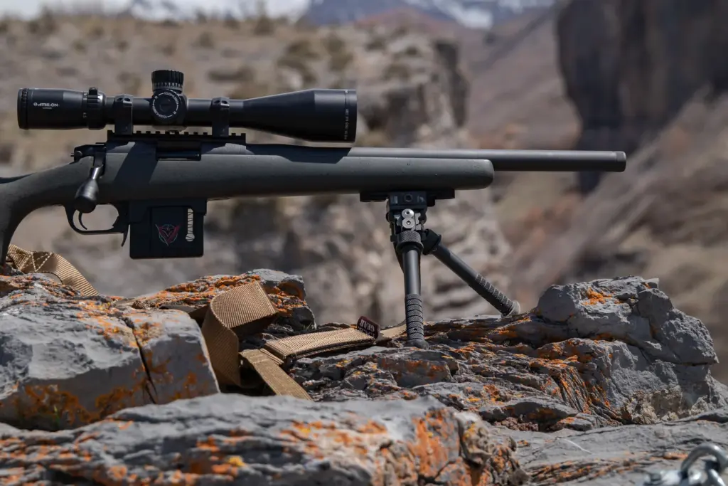 OD-green bolt-action rifle on the Atlas PSR BT46-LW17 bipod above a canyon