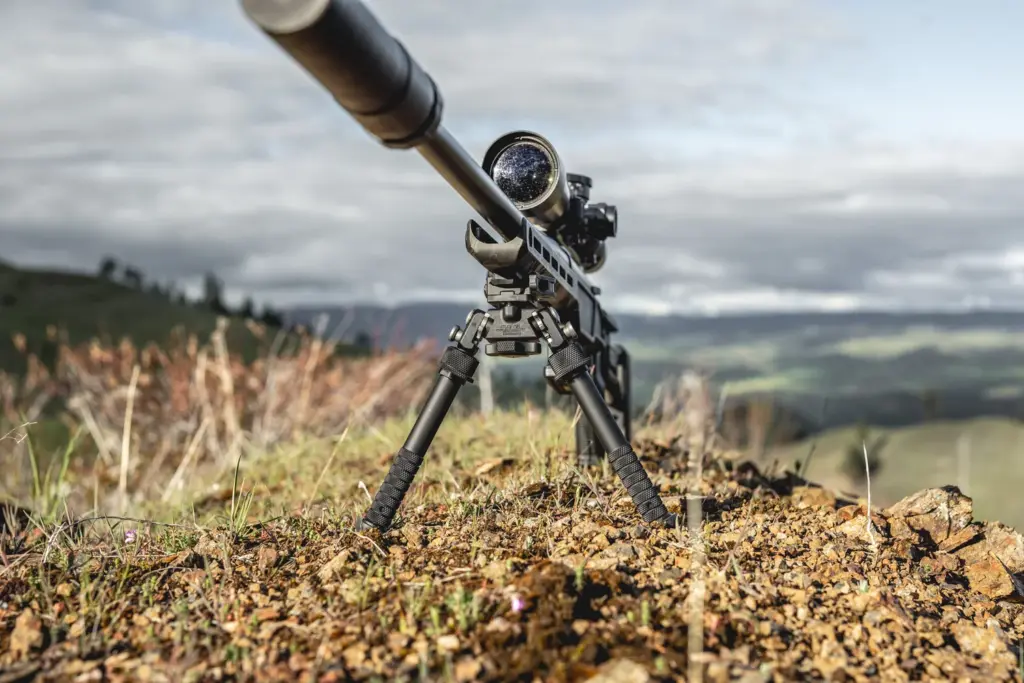 Low angle of a suppressed rifle on the Atlas PSR BT46-LW17 bipod overlooking a valley
