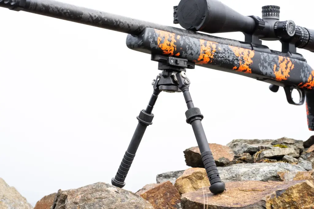Atlas PSR BT46-LW17 bipod under an orange digital-camo precision rifle on wet rocks