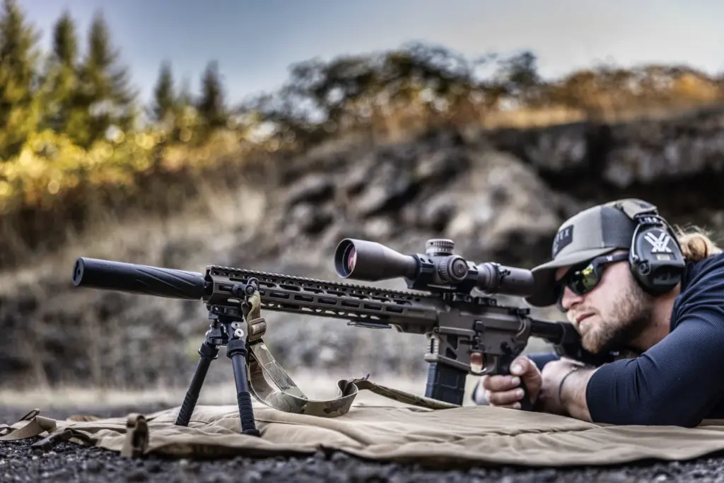 Shooter prone on a mat behind a suppressed M-LOK AR supported by the Atlas PSR BT46-LW17 bipod